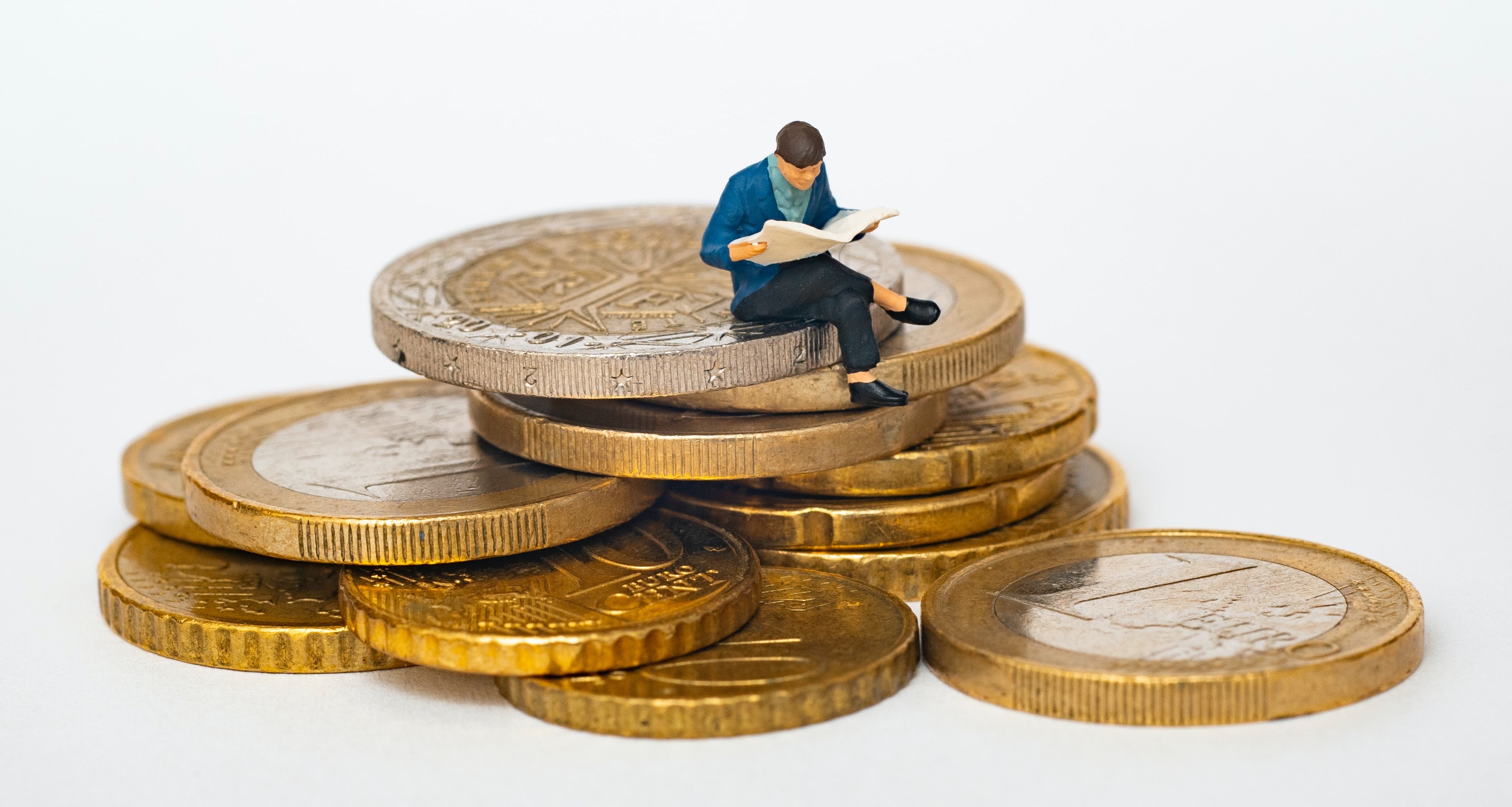 Person sitting on a pile of coins - achieving financial freedom or independence